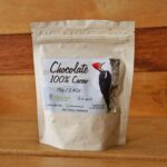 Imagen de un chocolate en media esfera de 70g, elaborado con cacao 100% natural, presentado sobre una superficie rústica