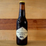 Botella de cerveza artesanal de chocolate Chocofruts sobre fondo rústico, con espuma cremosa y tonos oscuros que evocan el cacao.